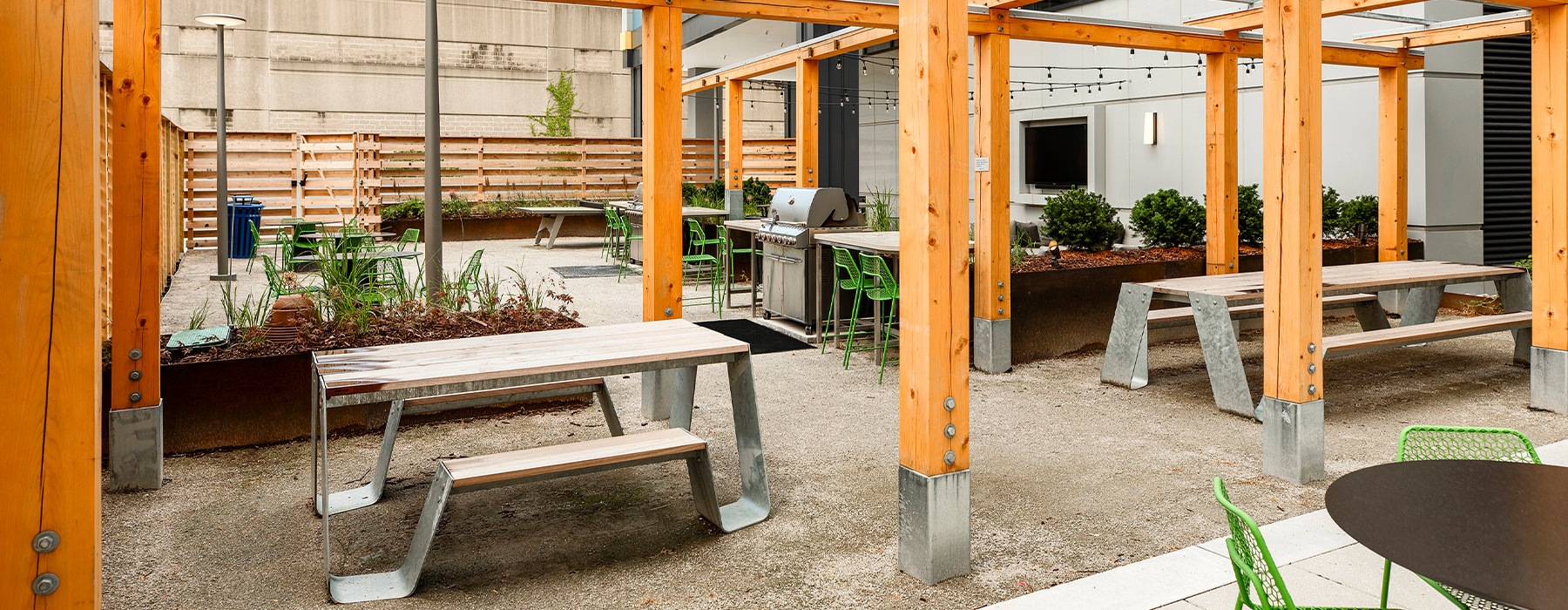 Outdoor community space with tables and a grill
